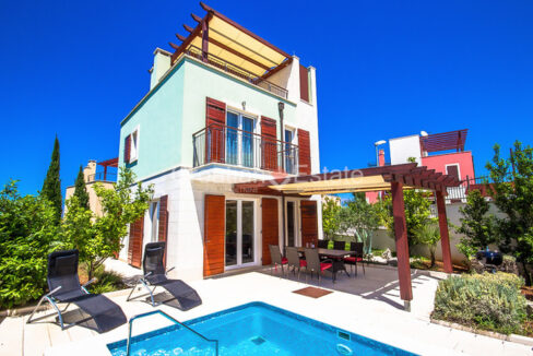 A villa for sale on Brac, Croatia, with a roof terrace with a pergola, a balcony, and a ground floor terrace with a pool.