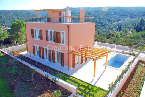 A villa for sale on Brac, Croatia, with a roof terrace and a patio with a pool, a pergola, and garden areas.