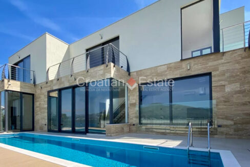 A villa for sale on Ciovo, Croatia, with large glass walls and a terrace with a pool.