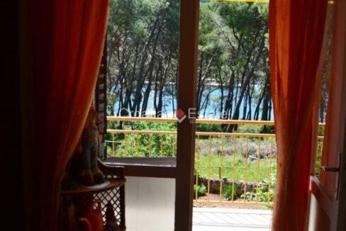 A seafront house for sale on Hvar, Croatia, vegatation in front of it.