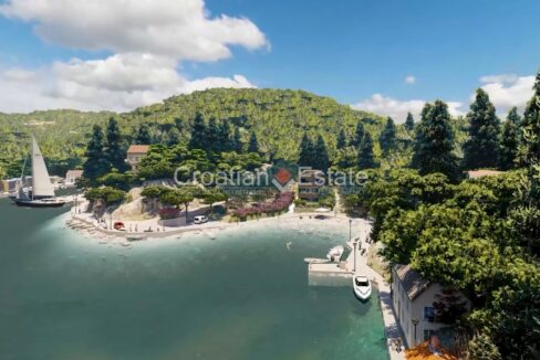 An apartment for sale on Korcula, Croatia, in a seafront building, a few boats, coast, a promenade, houses, and vegetation.