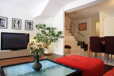 An apartment for sale in Split, Croatia, with a living room, a dining table with chairs, and stairs.