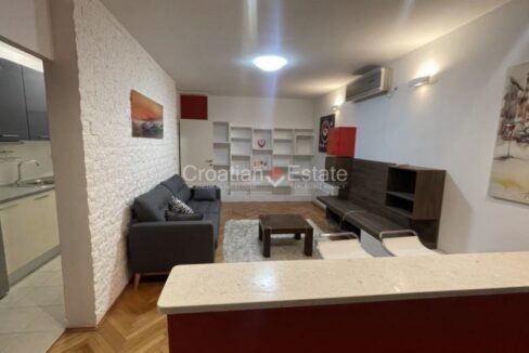An apartment for sale in Plokite, Split, Croatia, with a living room with a bar, furniture, and an air conditioner.