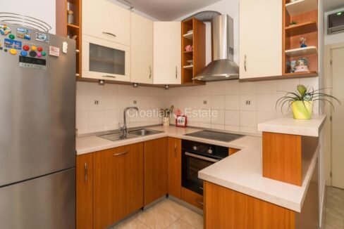 An apartment for sale in Sukoisan, Split, Croatia, with a kitchen with a large refrigerator and other kitchen equipment.