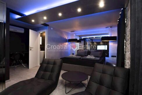 A modern apartment in Trogir, Croatia, with an air conditioner, a double bed, and other furniture.